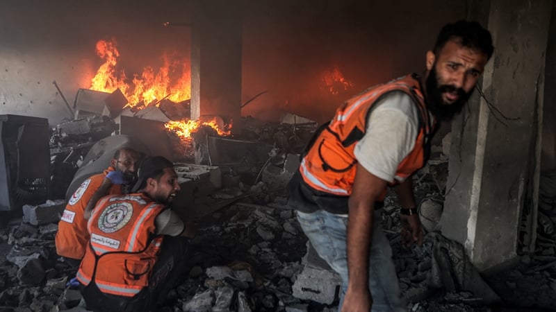 Palestinian civil defence try to extinguish a fire at a building hit by an Israeli strike in Gaza City in central Gaza