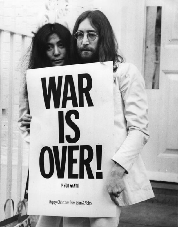 John Lennon (1940 - 1980) and Yoko Ono pose on the steps of the Apple building in London, holding one of the posters that they distributed to the world's major cities as part of a peace campaign protesting against the Vietnam War. 'War Is Over, If You Want It'. (Photo by Frank Barrett/Keystone/Hulto
