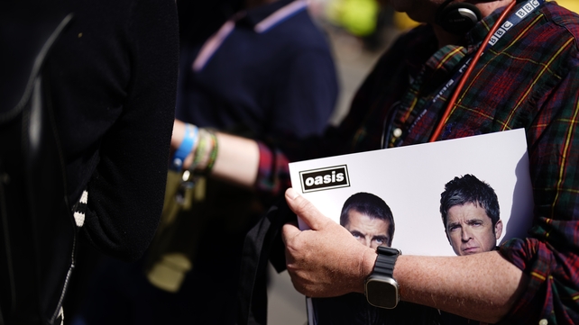 An Oasis fan holding a record ahead of the opening night of the Oasis Live '25 Tour