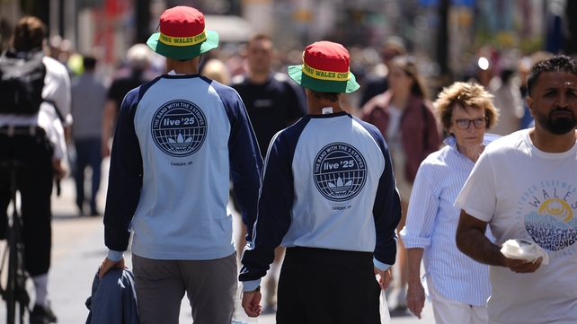 Oasis fans wearing merchandise from the band collaboration with Adidas, and Wales-themed bucket hats