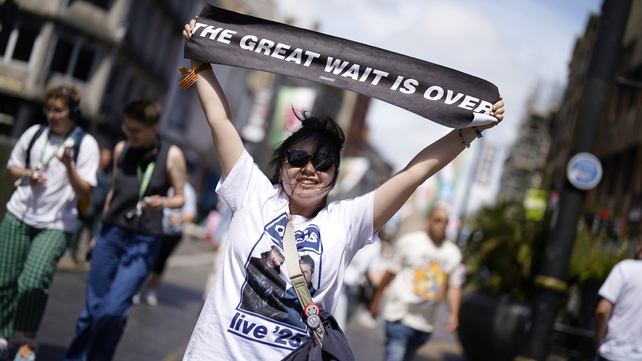 An Oasis fan holds up a banner which reads "The great wait is over" in Cardiff