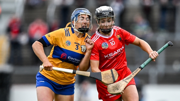 20 April 2025; Saoirse McCarthy of Cork is tackled by Clare Hehir of Clare during the Munster Senior Camogie Championship semi-final match between Clare and Cork at Zimmer Biomet Páirc Chíosóg in Ennis, Clare. Photo by Brendan Moran/Sportsfile