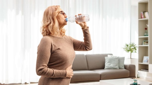 a person drinking water from a plastic bottle