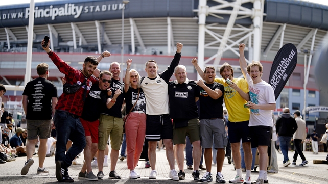 Oasis fans pose outside the Principality Stadium, Cardiff