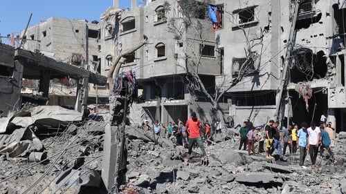 Palestinians inspect the damage after an Israeli strike in the Al-Bureij camp in central Gaza