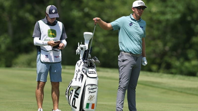 Séamus Powerpulls a club from his bag as caddie Simon Keelan looks on during the second round