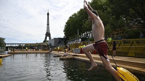 A swimmer jumps in the water at the Grenelle safe bathing site on the Seine river on its opening day