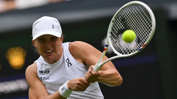 Poland's Iga Swiatek plays a backhand return to US player Danielle Collins during their women's singles third round tennis match on the sixth day of the 2025 Wimbledon Championships at The All England Lawn Tennis and Croquet Club in Wimbledon, southwest L
