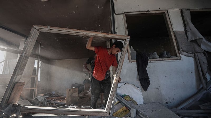 Palestinians inspect the damaged building of the Al-Rimal Clinic in Gaza City