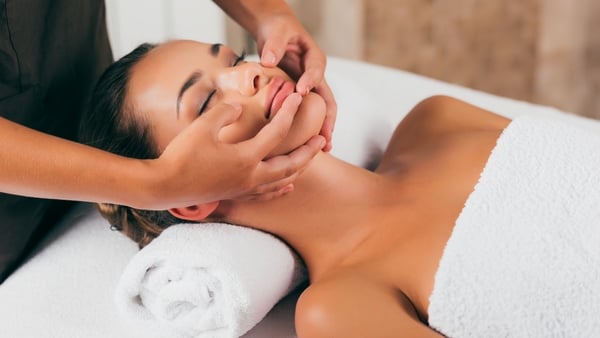 beautiful woman having face massage in spa salon