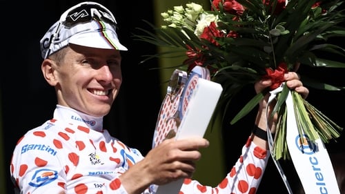 Tadej Pogacar celebrates on the podium with the best climber's polka dot jersey after the fourth stage