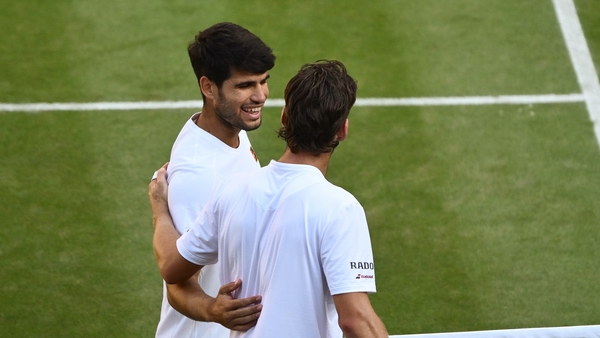 Carlos Alcaraz of Spain meets Cameron Norrie of Great Britain at the net following his victory during the Gentlemen's Singles quarter-finals match on day nine of The Championships Wimbledon 2025 at All England Lawn Tennis and Croquet Club on July 08, 2025