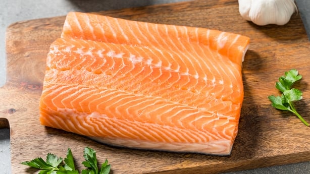 a piece of salmon on a wooden board