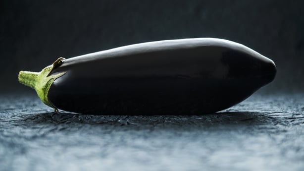 An aubergine on a blue surface