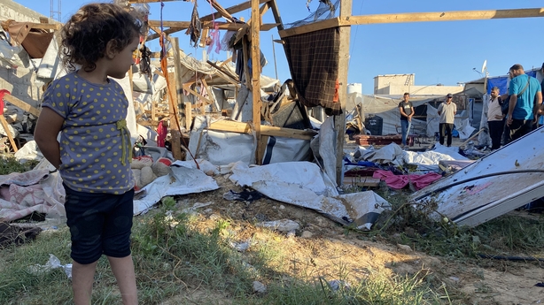 Palestinian girl looks at damage after an Israeli strike at a camp for displaced people near Khan Yunis in southern Gaza 