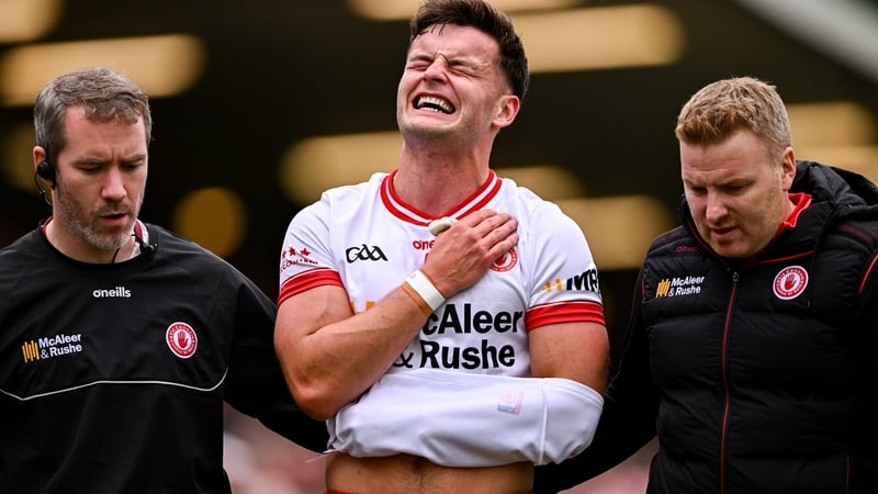 Tyrone's Michael McKernan (C) of leaves the pitch after being injured against Cavan