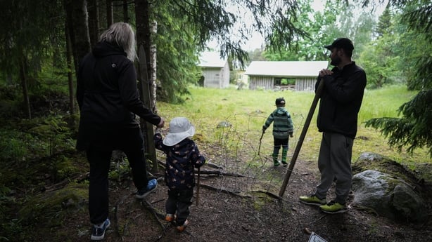 Oona Stenberg and Petri Stenberg walk with their children outside their rented cottage in Isojarvi National Park, Langelmaki, Finland