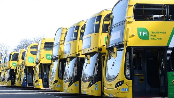 A number of yellow Dublin Buses are parked in a row.