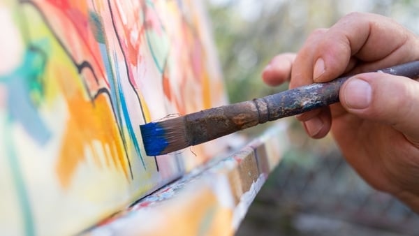 Fine art painter painting outdoor, Close up of artist holding brush