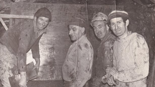 Four men working and smiling