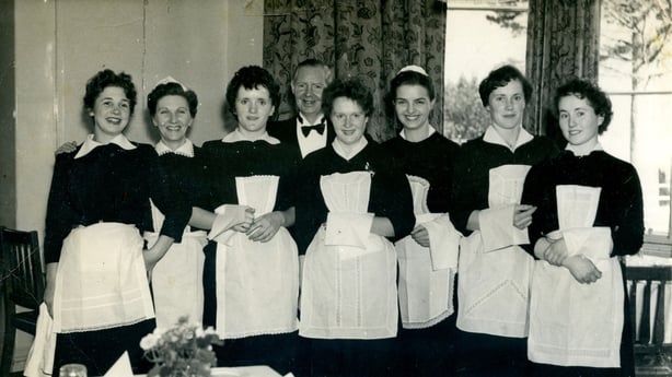Seven women and a man smiling for a photo