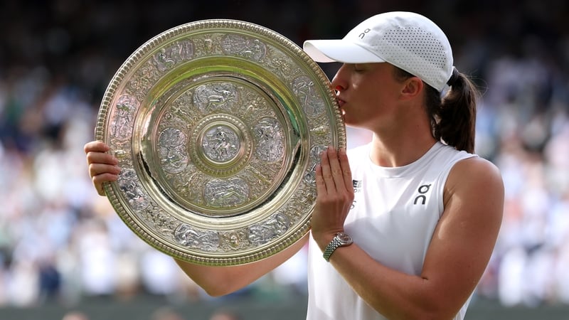 Iga Swiatek kisses the trophy after her emphatic victory