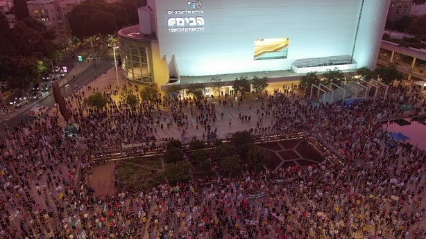 An aerial view shows hundreds of people gathering for a protest in Tel Aviv as they march with photos of hostages held in Gaza