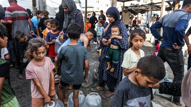 People collect water at an UNRWA shelter in Khan Younis