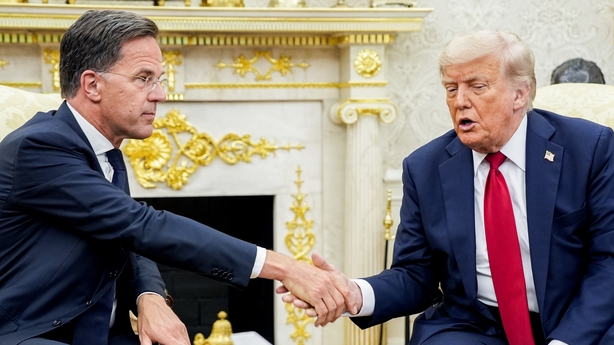 two men shaking hands in a room
