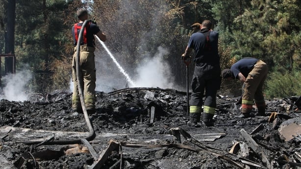 Firefighters pour water on cinders during a response effort to a Russian drone attack in a suburb of Dnipro, Ukraine, on July 14, 2025. (Photo by Mykola Miakshykov/Ukrinform) NO USE RUSSIA. NO USE BELARUS. (Photo by Ukrinform/NurPhoto via Getty Images)
