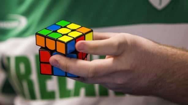 Man in an Ireland jersey holding a Rubik's Cube