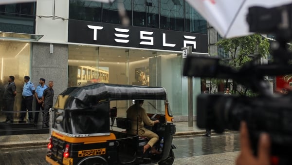 A rickshaw passes the first Tesla sales room in Mumbai, India