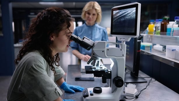 a person looking through a microscope