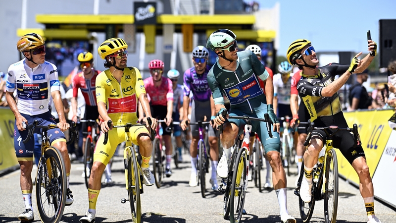 Tour de France leader Ben Healy, in yellow, poses for a selfie ahead of the start of stage 11