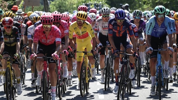 EF Education - EasyPost team's Irish rider Ben Healy wearing the overall leader's yellow jersey (C) cycles with the pack of riders (peloton) during the 11th stage of the 112th edition of the Tour de France cycling race, 156.8 km starting and finishing in