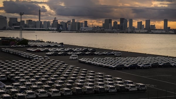 New vehicles parked at a port at dusk in Japan