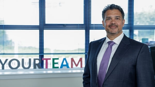 Niresh Moodley, CEO of YourTeam, posed for a photo beside the company's logo