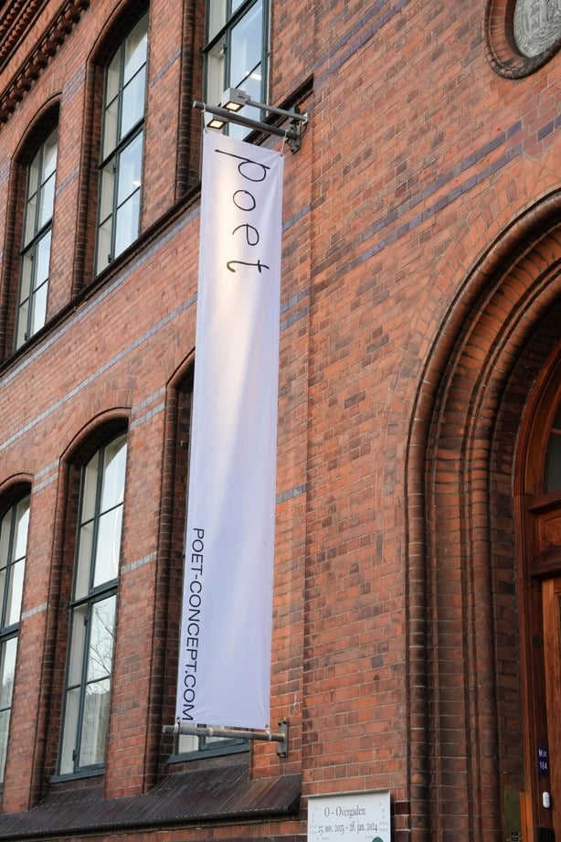 a white banner reading 'poet' on a brick building