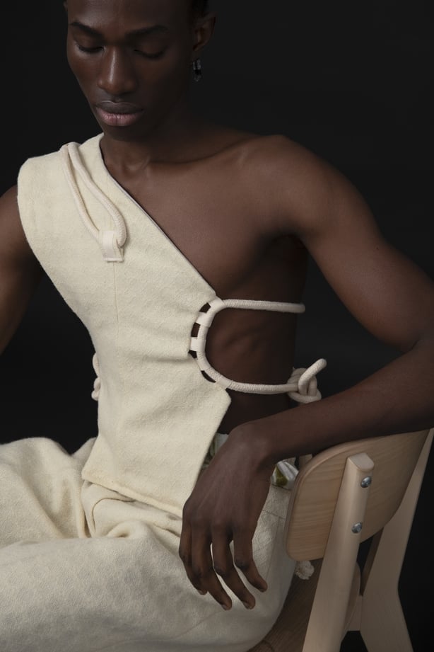 a person sitting in a chair wearing a cream two piece set