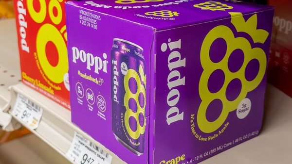 Cases of Poppi soda in a purple box on a store shelf