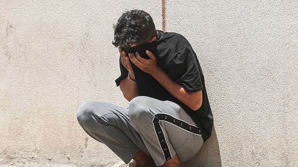 A relative covers his face as he waits outside the forensic department of the al-Zahraa Hospital on July 17, 2025, after a fire tore through the newly opened Hyper Mall overnight in the eastern Iraqi city of Kut, killing at least 60 people, according to Iraqi authorities. Officials have launched an 