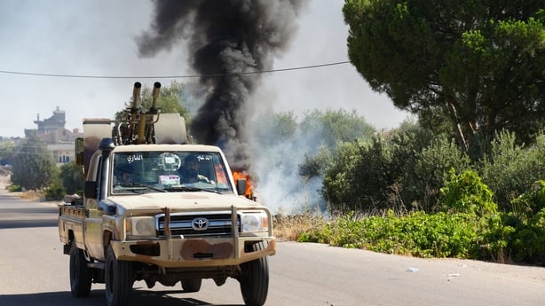 a truck driving on the road with black smoke behind it