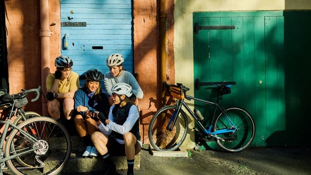 Group of women cyclists taking a break and chatting at an urban cafe