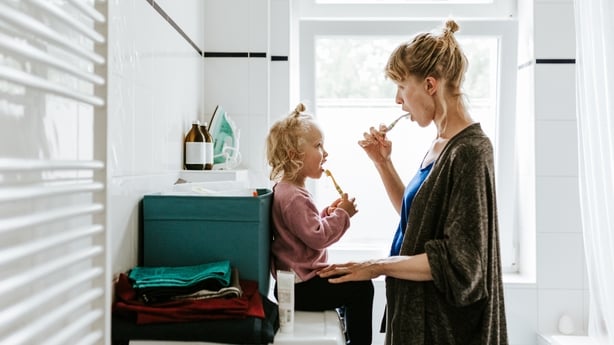 Young mother with a child brushing their teeth