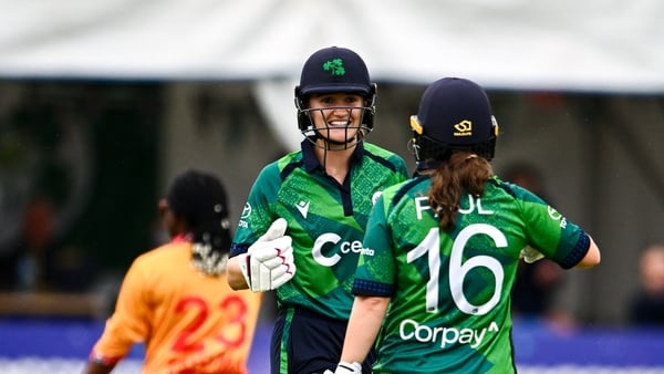 20 July 2025; Gaby Lewis of Ireland celebrates with teammate Lara Paul, 16, after hitting a boundary during match one of the Women's T20 International Series between Ireland and Zimbabwe at Pembroke Cricket Club in Dublin. Photo by Ben McShane/Sportsfile