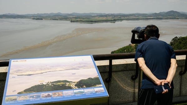 A tourist uses binoculars to watch the North Korean side of the Demilitarized Zone dividing the two Koreas, from South Korea's Odusan Unification Observatory in Paju on June 12, 2025