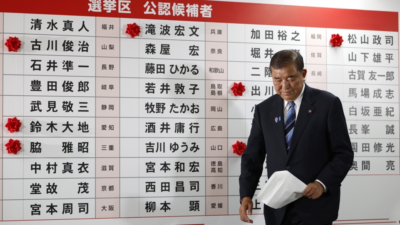 Shigeru Ishiba is seen in front of a board with few red paper roses showing elected candidate at his party's headquarters in Tokyo