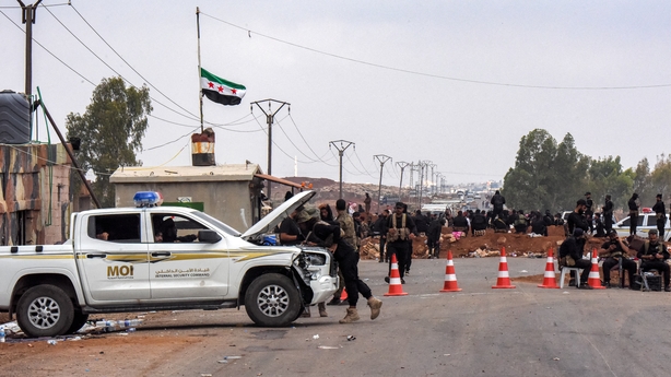 Members of the Syrian government security forces deploy on a road in Taarah, in Syria's southern Sweida province on the way to Daraa