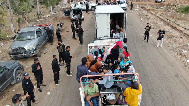 A truck carrying evacuating members of the Bedouin community stopping at a checkpoint set up by Syrian government forces along a road in Taarah