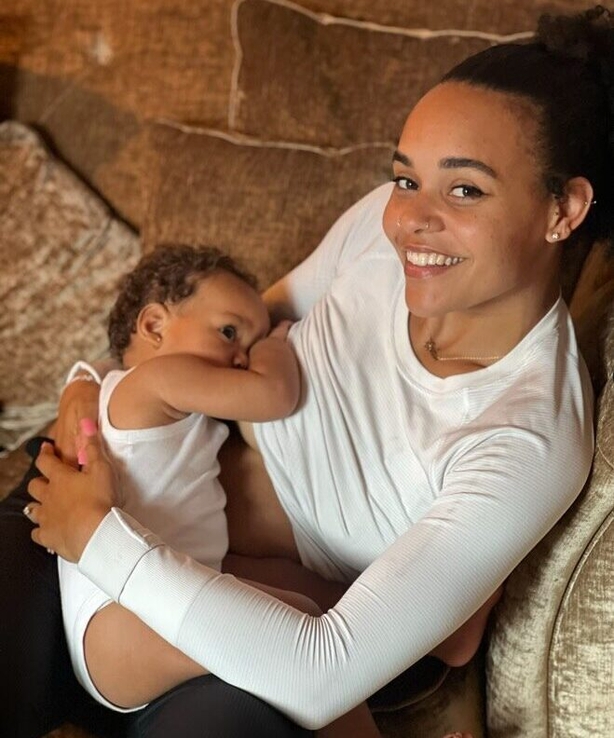 a woman holding a baby breastfeeding